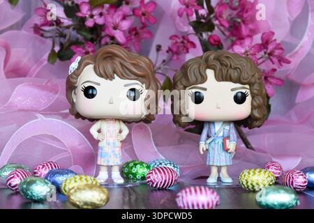 Funko Pop action figure di Robin e Nancy come accademici della serie TV Stranger Things. Uova di Pasqua in miniatura colorate, fiori viola, cortina rosa. Foto Stock