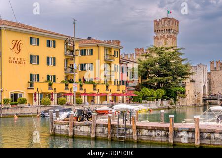 Sirmione, Italia - 12 agosto 2019: Veduta del paese di Sirmione, il famoso castello, barche e alberghi Foto Stock
