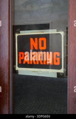 Cartello con la scritta "No Parking" di fronte a un negozio in un vicolo stretto nel centro storico di Riva del Garda, in Italia Foto Stock