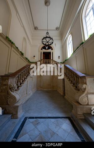 La Valletta, Malta - 13 agosto 2025: Scalinata in marmo barocco all'interno del Palazzo dei grandi maestri del XVI secolo a la Valletta, con alte balaustre ornate Foto Stock