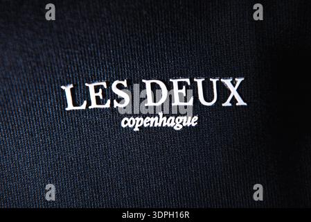 Logo Les Deux Copenhague su abbigliamento nero con luce parassita. Scritta in rilievo bianca su tessuto a coste scure con luce artistica eff Foto Stock