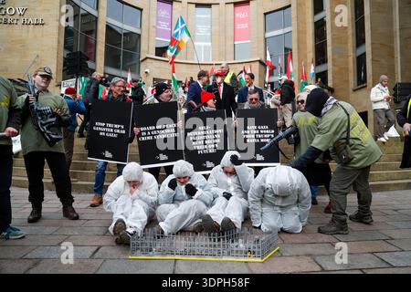 I manifestanti hanno svolto il ruolo di prigionieri palestinesi insieme ad altri come "forza offensiva israeliana" in quanto membri dei gruppi di sostegno palestinesi riuniti presso l'arco McLennan a Glasgow Green prima di marciare verso Buchanan Steps nel centro di Glasgow il 14 febbraio 2026. Questo per dimostrare sostegno al popolo palestinese nel mezzo del conflitto in corso. I manifestanti hanno anche espresso opposizione ai commenti del presidente degli Stati Uniti Donald Trump che suggeriscono che gli Stati Uniti potrebbero "prendere il sopravvento" e "possedere" la Striscia di Gaza. I partecipanti portavano bandiere e striscioni palestinesi che chiedevano pace, giustizia e a internazionale Foto Stock