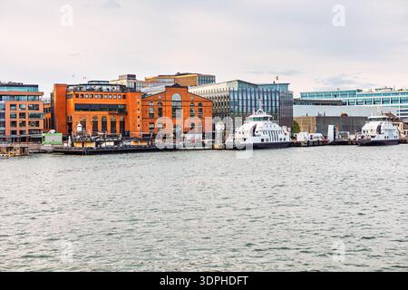 Aker Brygge Waterfront a Oslo, Norvegia, con storici magazzini in mattoni rossi. I moderni traghetti sono attraccati lungo il porto Foto Stock