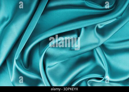 Raso lucido di seta turchese increspato con tendaggi ondulati. Tessuto lucido e liscio con pieghe morbide, tessuto. Elegante e ricco backgroun Foto Stock