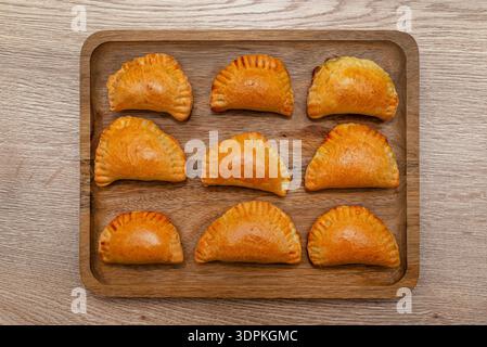 Polpettine di funghi dorati appena sfornate adagiate su un asse di legno. Foto Stock