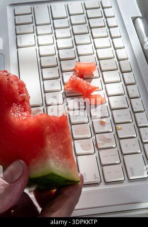 Primo piano dell'anguria versata sulla tastiera di un computer, 2026, Stati Uniti Foto Stock