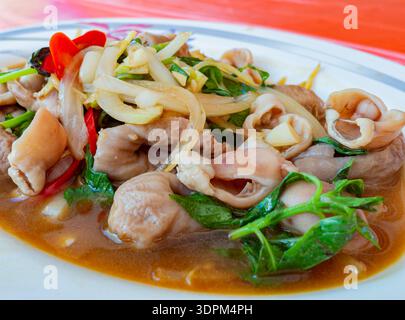 intestini di maiale croccanti saltati in padella con basilico fresco Foto Stock