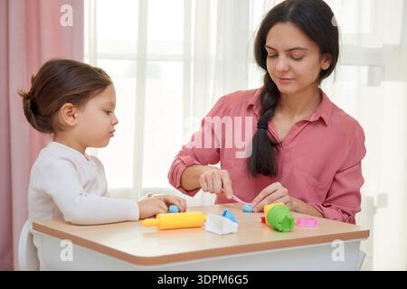 Madre e figlia si divertono a imparare la creatività con l'argilla da modella a casa Foto Stock
