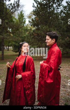 Coppie multiculturali che celebrano matrimoni tradizionali cinesi all'aperto Foto Stock