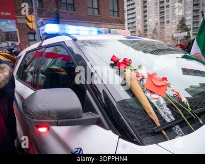 Fiori che sono stati collocati su un'auto della polizia dai manifestanti per gratitudine durante una massiccia manifestazione per la libertà per l'Iran il 14 febbraio 2026. Foto Stock
