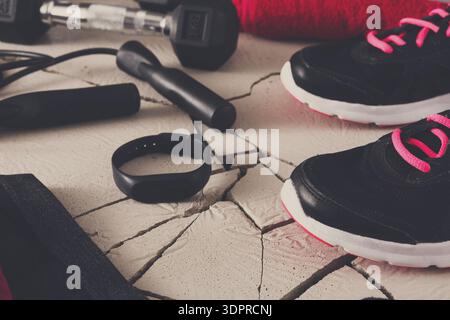 Attrezzatura e scarpe per l'allenamento su una superficie incrinata pronti per la sessione di allenamento a casa Foto Stock