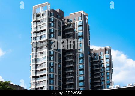 Moderni ed alti edifici di appartamenti con balconi in vetro sotto il cielo azzurro e limpido nel paesaggio urbano Foto Stock