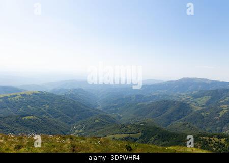 Vista su colline e valli verdi ondulate ricoperte di vegetazione lussureggiante sotto un cielo sereno, Midzor, Bela Palanka, Pirotski Okrug, Serbia. Foto Stock