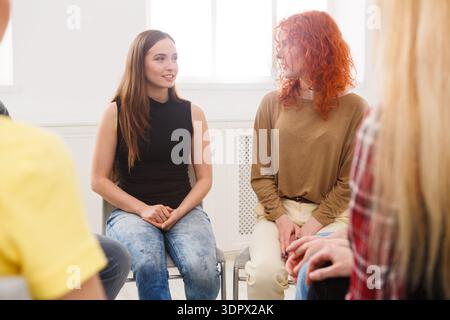 Due donne si impegnano in una conversazione durante una riunione di gruppo in una Bright Room Foto Stock