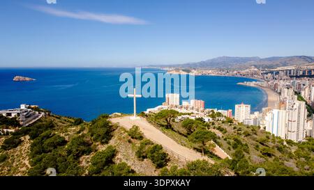 Vista aerea dal Mirador de la Cruz, che mostra la Cruz de Benidorm con vedute panoramiche della costa mediterranea, della vegetazione lussureggiante e della u Foto Stock