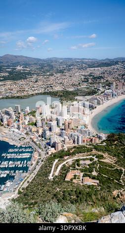 Vista aerea della costa di Calpe presa dal Penon de Ifach. Il paesaggio urbano si fonde con le splendide spiagge e il porticciolo, sotto la chiara Costa Blan Foto Stock