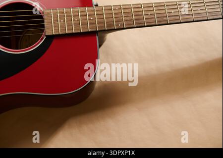 Primo piano di una chitarra acustica rossa che illustra la manutenzione della chitarra, la regolazione delle corde e i concetti di riparazione per la sintonizzazione, il contenimento e l'attenta strumentazione della vettura Foto Stock