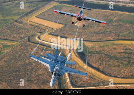 MX Aircraft MXS-RH N530RH seriale MXS-001 esegue acrobazie di precisione con Boeing F/A-18F Super Hornets 165672 ad-205 e 165887 ad-206 VFA-106 al Sun N Fun Aerospace Expo 2024, Florida. MXS-RH è un aereo acrobatico ad ala bassa, alimentato da Lycoming AEIO-540, monomotore. I Super Hornets sono dotati di doppio sedile, doppio motore, turboventilatore GE F414-GE-400 con postbruciatori, prolunghe bordo anteriore e carrello di atterraggio retrattile. La foto in primo piano aria-aria cattura il controllo del pilota, le tracce di vapore e le prestazioni di manovra durante il volo di formazione. Foto Stock