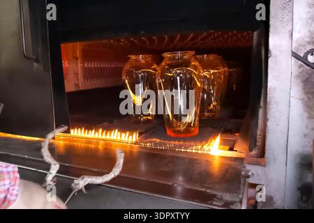 Fusione del vetro da materiali riciclati, riscaldamento del vetro sul fuoco. Foto Stock