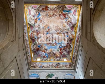 La vista di vivaci affreschi e dettagli ornati adornano il soffitto a volta, una sinfonia di colori e arte a San Lorenzo de El Escorial, Comunidad de Mad Foto Stock