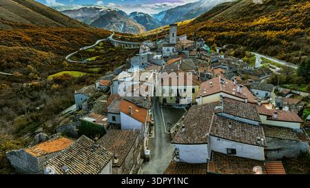 Veduta aerea del borgo medievale di Cocullo con la torre dell'orologio in primo piano e le montagne circostanti del parco. Cocullo, Abruzzo Foto Stock