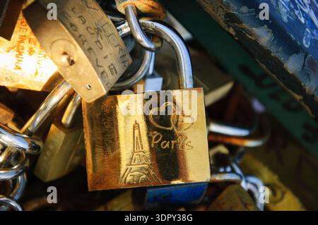 PARIGI, FRANCIA - 21 GIUGNO 2014: Serratura d'amore con Torre Eiffel e cuori intagliati attaccati al ponte alla luce dorata del tramonto. Rituale di apposizione dei lucchetti t Foto Stock