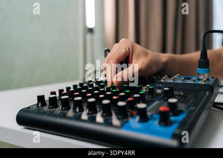 Regolazione manuale di varie manopole sulla console del mixer audio, controllo dei livelli e degli effetti audio per l'ingegneria del suono, la produzione musicale, il podcasting o. Foto Stock