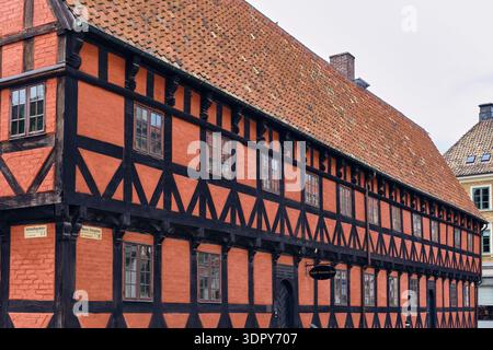 Helsingborg, Svezia - 12 agosto 2025: Veduta di uno storico edificio incorniciato in legno con vivaci pareti rosse e travi di legno scuro, che riflettono un'atmosfera senza tempo Foto Stock