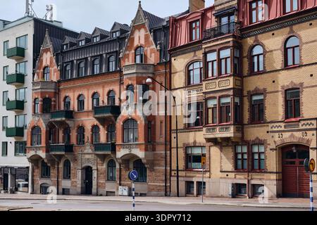 Helsingborg, Svezia - 12 agosto 2025: Veduta di edifici in mattoni con facciate dettagliate, le loro tonalità rosse e gialle contrastano con il cielo coperto. Foto Stock
