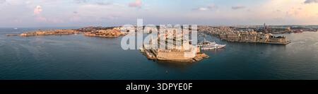 Panorama aereo del forte Sant'Angelo sulla penisola di Birgu nel Porto grande di Maltas, con porticcioli, yacht e il lungomare di la Valletta al crepuscolo. Foto Stock
