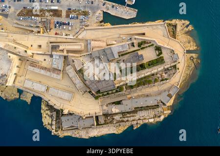 Veduta aerea del forte Sant'Angelo sulla penisola rocciosa di Birgu, Malta, mostrando le mura dei bastioni, i cortili e il mare Mediterraneo circostante. Foto Stock