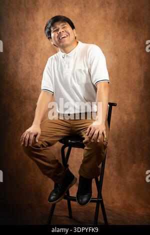 Giovane uomo che ride in posa Foto Stock