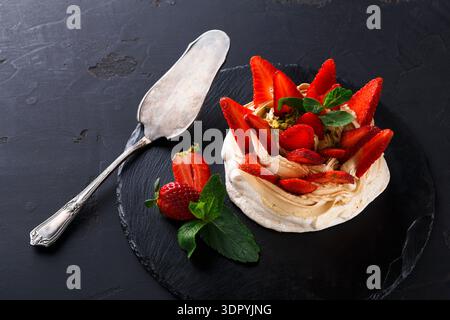 Delizioso dessert a base di meringa, panna e fragole fresche servito su un piatto Foto Stock