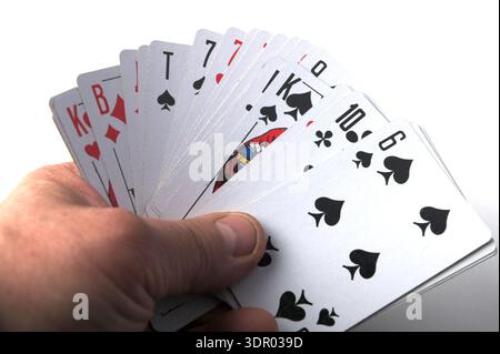 Leopoli, Ucraina, 4 marzo 2025. Una mano tiene un fan delle carte da gioco, tra cui il Re delle picche, dieci dei club e sei delle picche. Le carte sono aperte Foto Stock