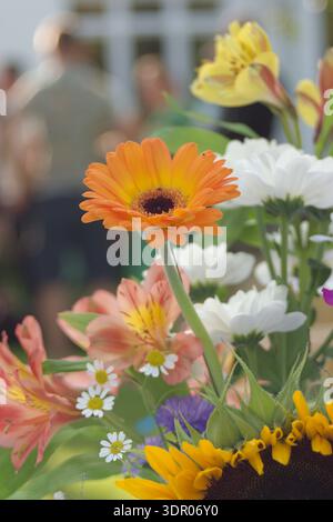 Bellissimo bouquet di fiori con un gruppo di persone sullo sfondo Foto Stock