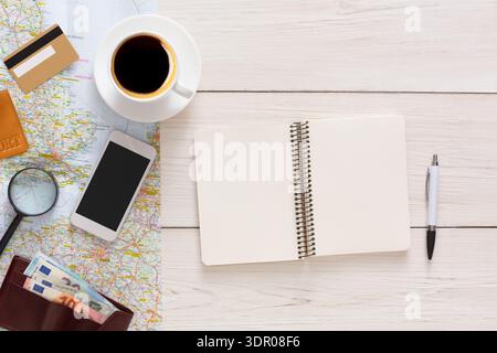 Pianifica un'avventura di viaggio con cartina, caffè e oggetti da viaggio su un tavolo di legno Foto Stock