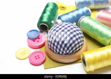 Molti materiali di cucito diversi su sfondo bianco, primo piano Foto Stock