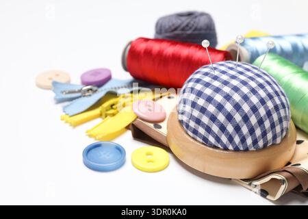 Molti materiali di cucito diversi su sfondo bianco, primo piano Foto Stock
