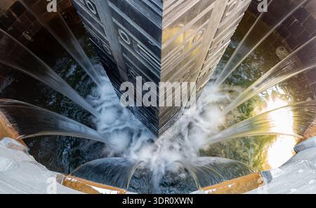 Flussi d'acqua dinamici fluiscono dalla moderna struttura della fontana. Foto Stock