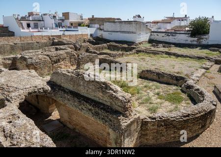 Struttura ricurva in mattoni e fondazioni circostanti nelle terme romane di Itálica, Santiponce, Andalusia, Spagna, che mostrano la disposizione delle antiche terme Foto Stock