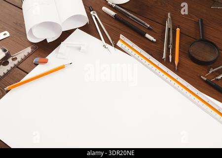 Una collezione di strumenti e forniture per disegni è posizionata su un tavolo in legno Foto Stock