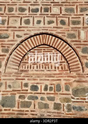 Frammento di muratura e archi della Moschea Dzhumaya a Plovdiv, Bulgaria. Architettura ottomana tradizionale che utilizza mattoni e pietra alternati. Foto Stock