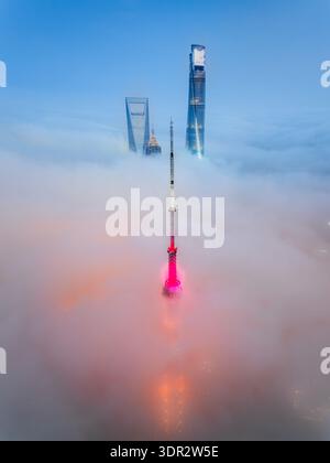 Vista aerea della Oriental Pearl Tower che attraversa un mare di nebbia, con grattacieli avvolti dalla nebbia, Shang hai Shi, Cina. Foto Stock