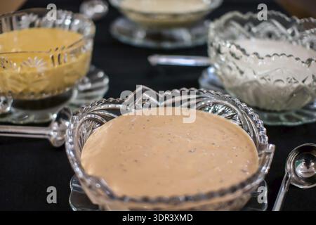 Vari condimenti per insalate in ciotole di cristallo al tavolo della festa Foto Stock
