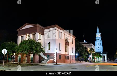 Edificio ignifugo a Charleston, South Carolina. La storica architettura revival greca presenta una base in pietra arenaria e colonne bianche vicino alla chiesa di San Michele di notte Foto Stock
