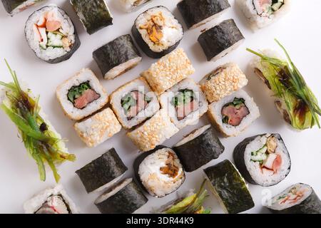 Collage di sushi con vari tipi e stili di rotoli di sushi su una superficie bianca Foto Stock