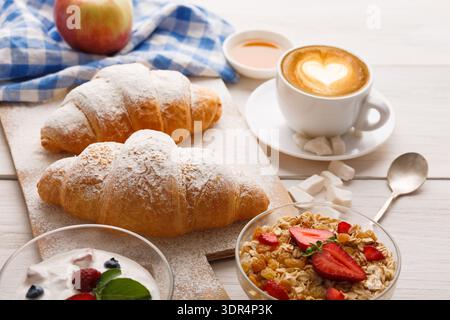 Gustate la colazione con croissant, yogurt e caffè su un tavolo di legno Foto Stock