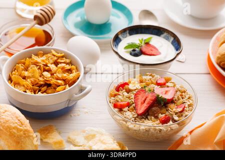 Bright Collection di cibi per la colazione disposti su un tavolo per pasti mattutini e spuntini Foto Stock