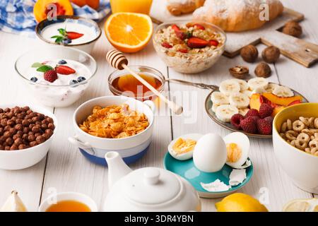 Colazione a buffet con frutta, cereali, yogurt e pane su un tavolo durante la mattina Foto Stock