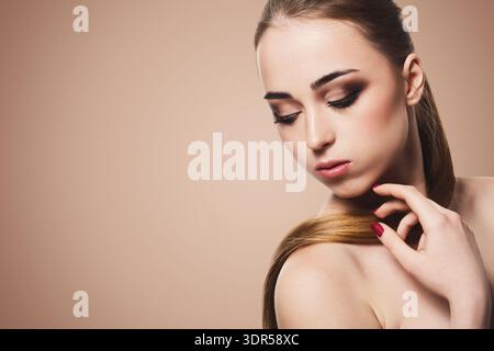 Modella posa in Studio con capelli lunghi e dritti durante una foto di bellezza Foto Stock